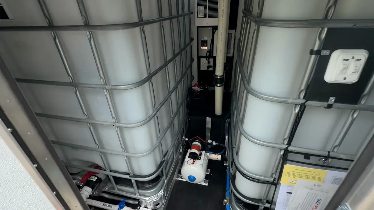 Interior of the box — two 330-gallon tanks with pump and plumbing between them