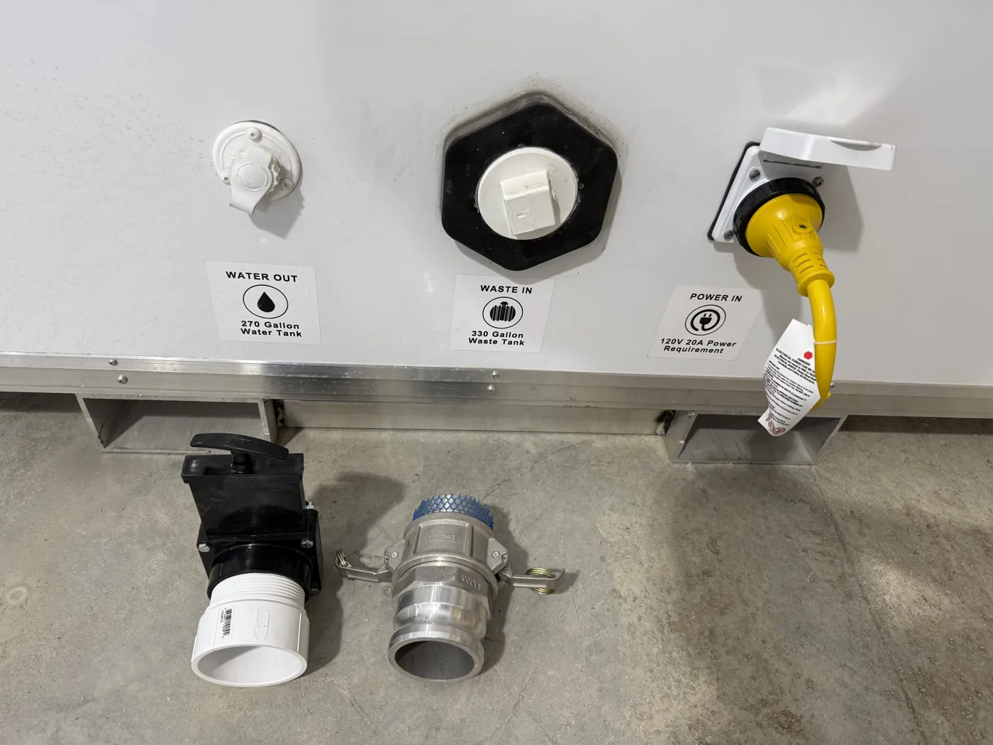 Trailer side of the box with three labeled connections: Water Out from the 270-gallon water tank, Waste In to the 330-gallon waste tank, and Power In with a 120V 20A power requirement